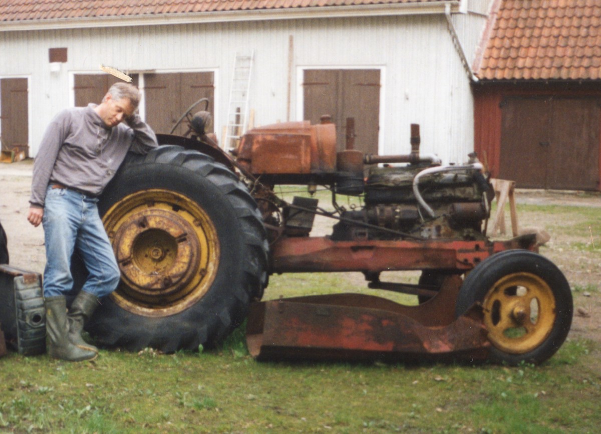 Här vilar sig Anders Stenström mot en gammal traktor.  Anders kanske undrar vad han gett sig in på när han börjat samla på diverse äldre jordbruksmaskiner.